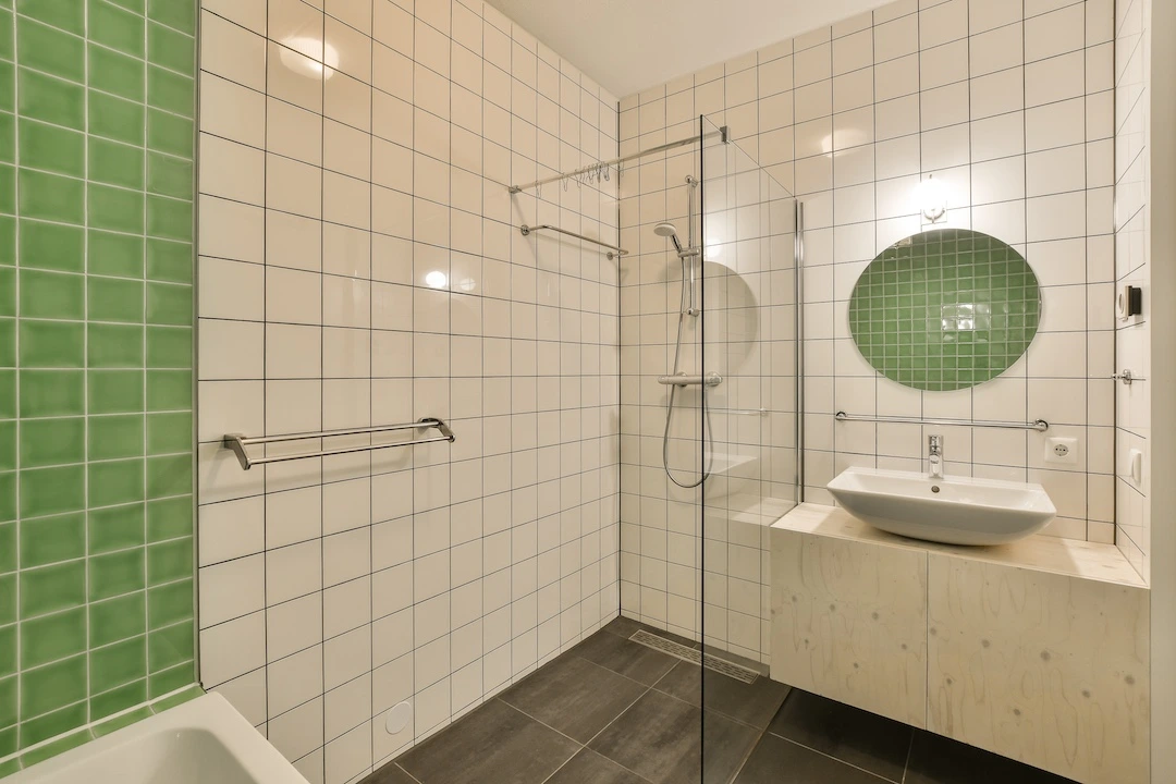 a tiled bathroom with a shower and a sink